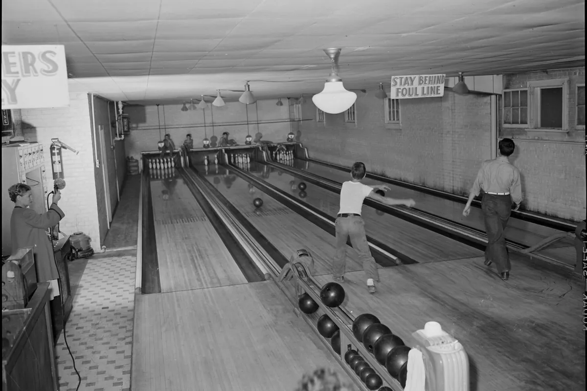 A four-lane bowling alley in 1946, with manual pinsetters at the far end of the lanes