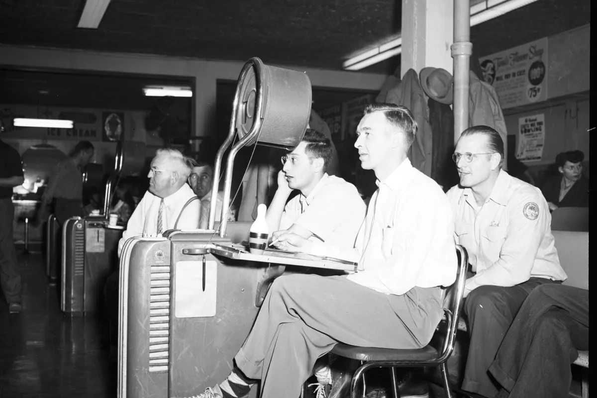 Joueurs de ligue assis à la table de marque d'un bowling dans les années 1950